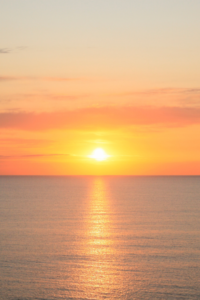 Sun rising above the horizon over the ocean reminds us of the Fresh Start Effect of a new day.