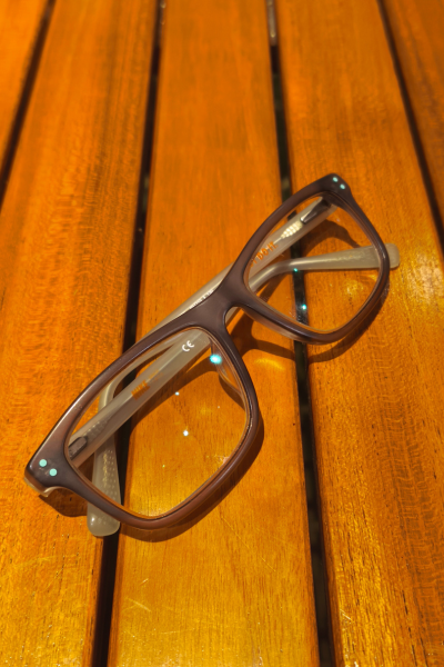 Child's eyeglasses laying on a picnic table.