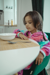A young child sitting at the head of the table